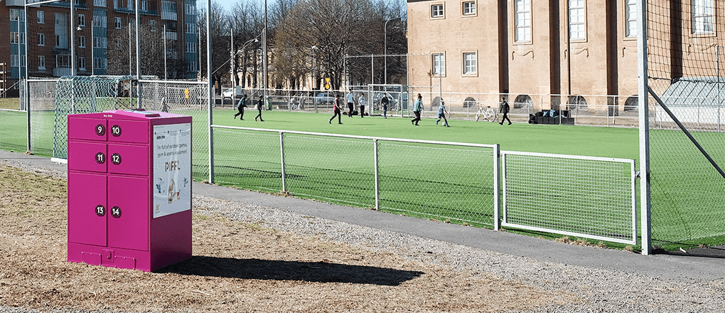 Piffl aktivitetsbox vid en fotbollsplan i Norrköping där barn spelar och har roligt